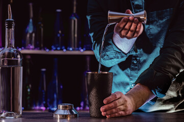 Bartender's hands serving cocktails on bar counter in a restaurant, pub. Mixed drinks. Alcoholic cooler beverage at nightclub on dark background