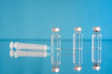 Vaccine bottles and syringe, treatment for coronavirus COVID-19, influenza or flu, worldwide mass vaccination for coronavirus,world immunization concept. Selective focus