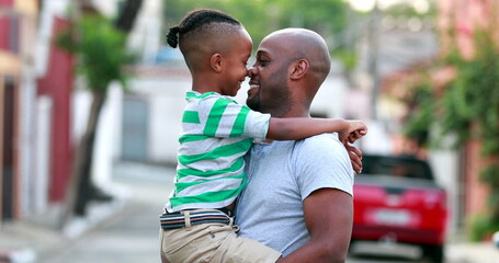 Father and son doing eskimo kiss. African black dad and child bonding together. Family love and affection