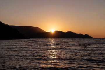 the outline of the mountains at sunset, the shore of the adriatic sea in croatia, summer sunset by the sea