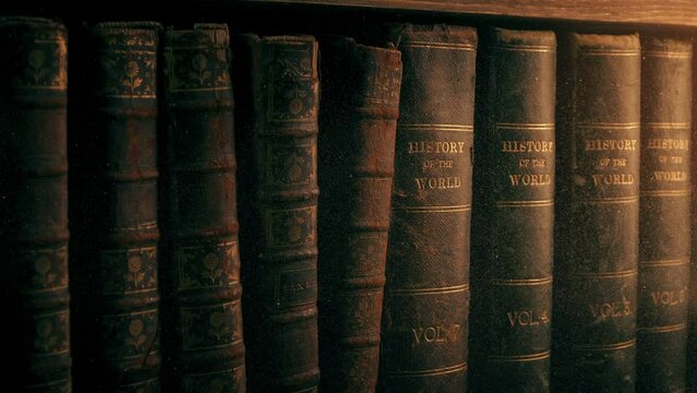 Passing Old Books With Dust Particles In Warm Lighting