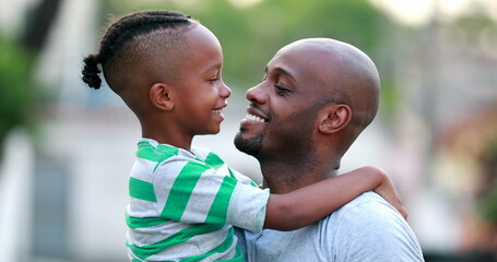 Father and son doing eskimo kiss. African black dad and child bonding together. Family love and affection