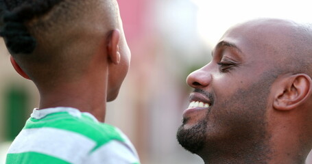 Fototapeta premium Father and child love care and affection. African ethnicity dad kissing son