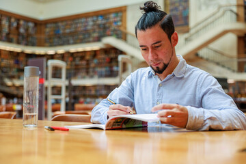 	広い図書館で勉強をする外国人留学生