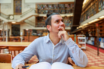 図書館でノートを広げて考えるチリ人男性