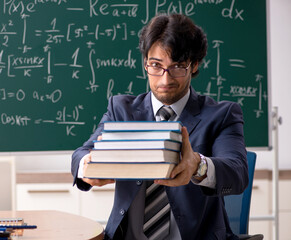 Young male math teacher in classroom