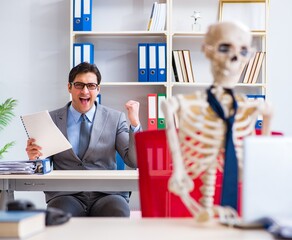 Businessman working with skeleton in office