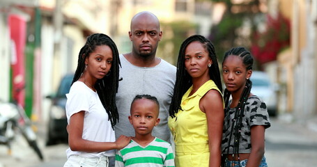 African family photo portrait standing outside. Black parents and children posing to camera