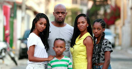 African family photo portrait standing outside. Black parents and children posing to camera