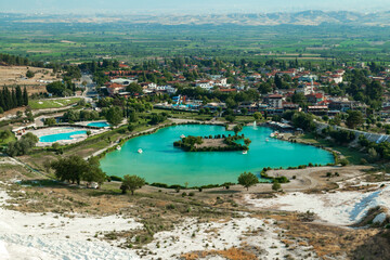 Fototapeta na wymiar Natural travertine pools and terraces in Pamukkale. Cotton castle in southwestern Turkey. Tourists walking and bathing in Natural travertine pools
