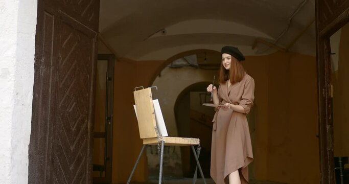 Girl artist with an easel under the arch