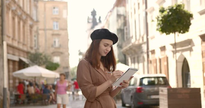 Girl artist with a notebook in her hands on the street