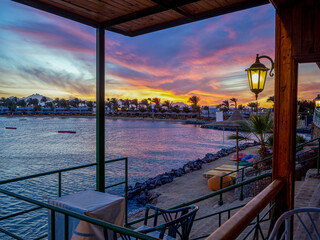 Sunset over the red sea palm tree silhuettes hotel in Hurgada, Egypt Sunrise and beach at the...