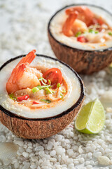 Spicy Tom Yum soup on beach with stones and seashells.
