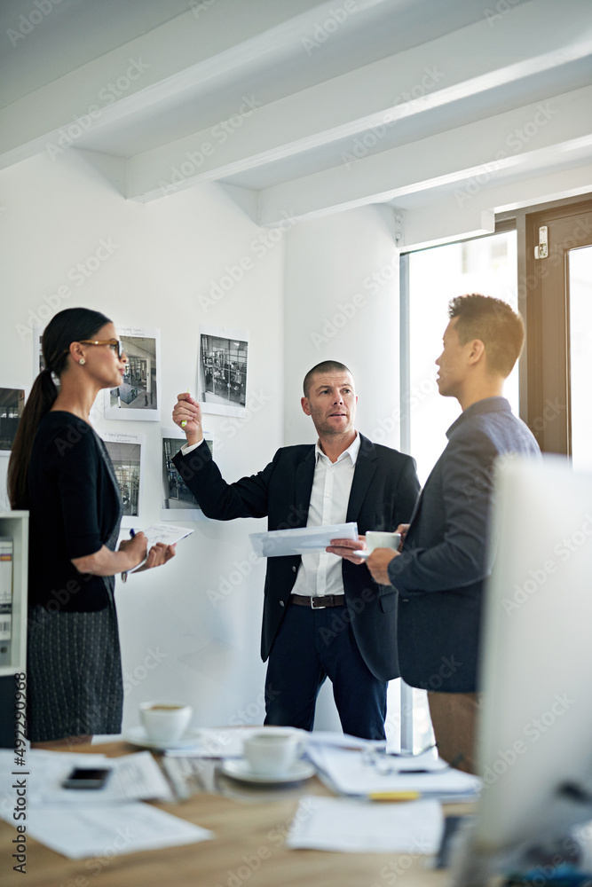 Poster discussing the best way to proceed. cropped shot of three colleagues working in the office.
