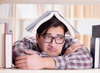 Young student looking for books in college library