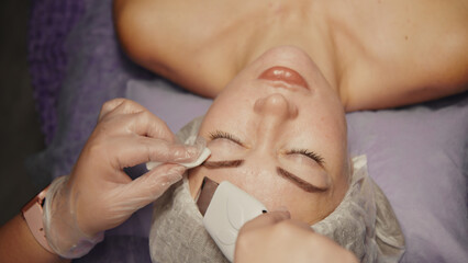 Woman cleansing facial in spa salon. Water oxygen face h2o2 small bubble facial rf lifting equipment skin care microdermabrasion machine. Wellness face care beauty treatment, rejuvenation procedure