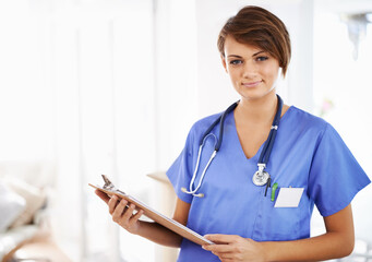 Shell take care of all your medical needs. Portrait of an attractive young doctor in scrubs holding...