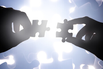 Fitting together the pieces. Cropped shot of hands holding two puzzle pieces.