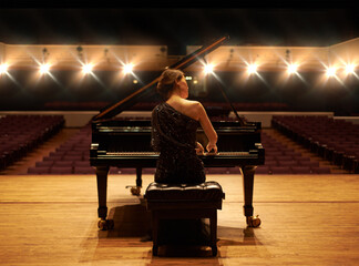 Showcasing her talent. Shot of a young woman playing the piano during a musical concert. © Alexandra W/peopleimages.com
