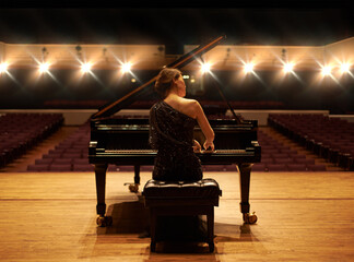Showcasing her talent. Shot of a young woman playing the piano during a musical concert.