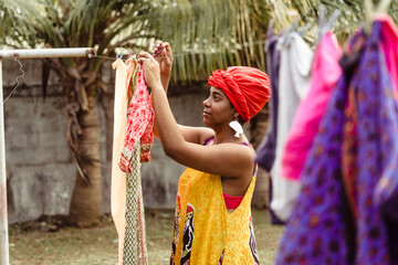 Black woman hanging washed clothes.