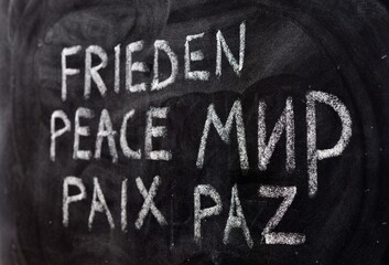 La palabra paz, escrito en ruso, ucraniano, alemán, inglés, francés y español, en una pizarra