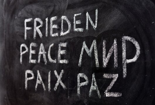 La palabra paz, escrito en ruso, ucraniano, alemán, inglés, francés y español, en una pizarra