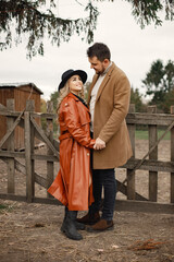 Romantic couple hugging on a farm near a fence