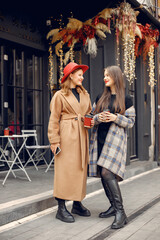 Two young girls standing near outdoor cafe and chatting.