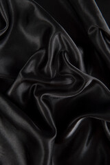 Abstract black silk fabric texture background. Creases of satin
