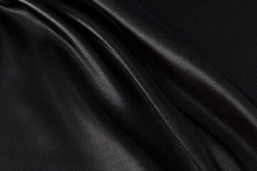 Abstract black silk fabric texture background. Creases of satin