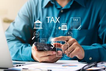 Businessman using his laptop computer and smartphone to fill out online personal income tax return form for tax payment, personal income tax calculation.