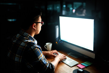 Putting his skills to work. Shot of a young male designer working on his computer late at night.