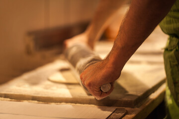 Pizza in creation. Cropped shot of a person rolling out pizza dough.
