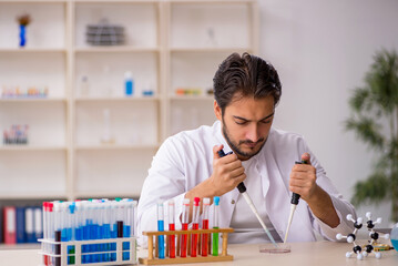 Young male chemist working at the lab