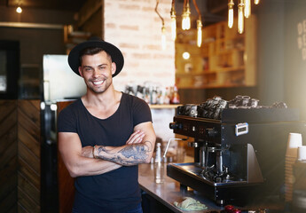 The leader in all things coffee. Shot of a handsome young man working behind the counter of a coffee shop.