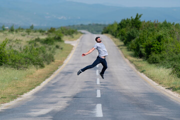 Muscular Man Jumping Outdoors at Highway