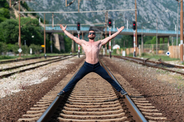 Model Flexing Muscles Outdoors at Railroad