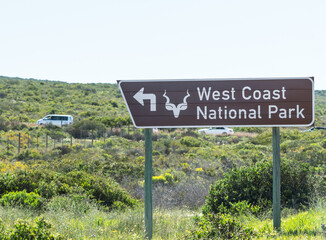 Obraz premium West coast national park road sign or signage showing directions to a place of interest in Western Cape, South Africa