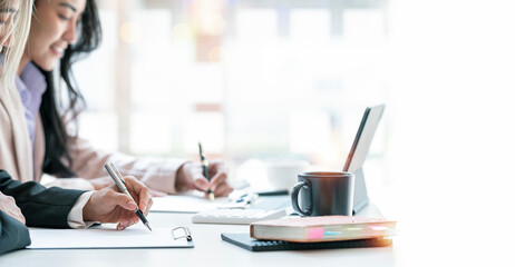 Professional business partner consulting the strategy and writing business plan at office desk.