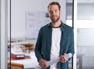 Fototapeta premium Drafting isnt just my job, its my passion. Portrait of a happy young architect standing in his office.