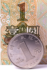A coin in denomination of one Chinese yuan against the background of a fragment of a one-yuan note