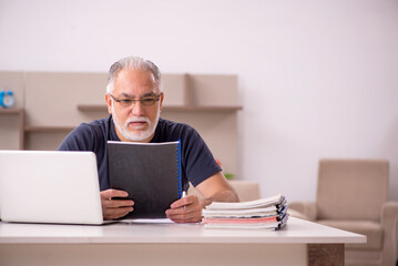 Old male employee working from home during pandemic