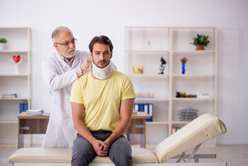 Obraz premium Young male neck injured patient visiting old male doctor
