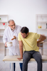 Obraz premium Young male neck injured patient visiting old male doctor