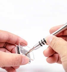 Electronic technician removing metal nut with a precision screwdriver for electronic repair on white background