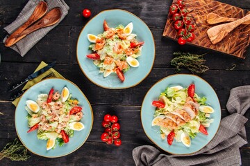 Top view on different types of caesar salad with chicken salmon and shrimp