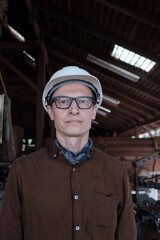Worker in a construction helmet in a warehouse or workshop