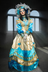 Obraz premium Performers in costume for a Venetian carnival against window.
